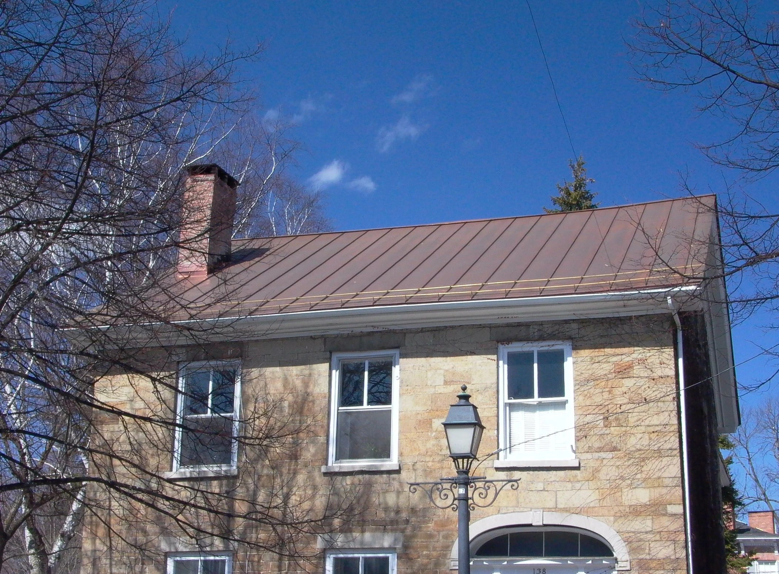 Stone building with a gray standing seam roof