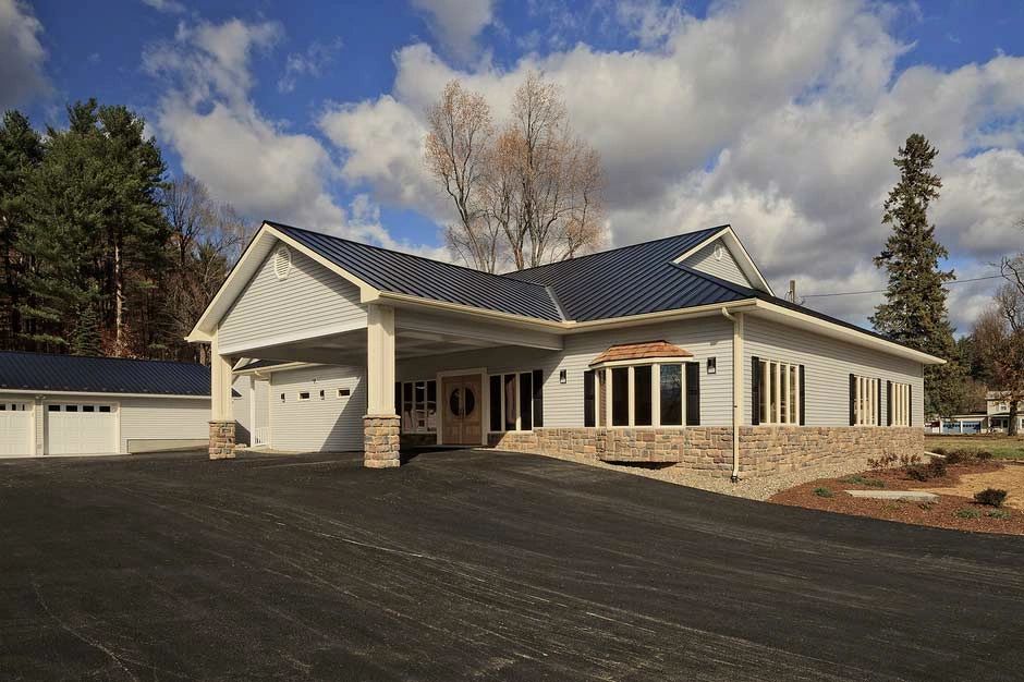 Gray metal roof over a low building with a columned entrance
