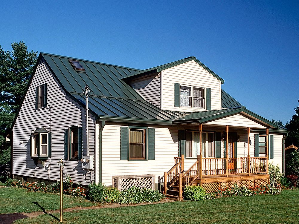 Light-colored home with a dark metal roof and wood porch