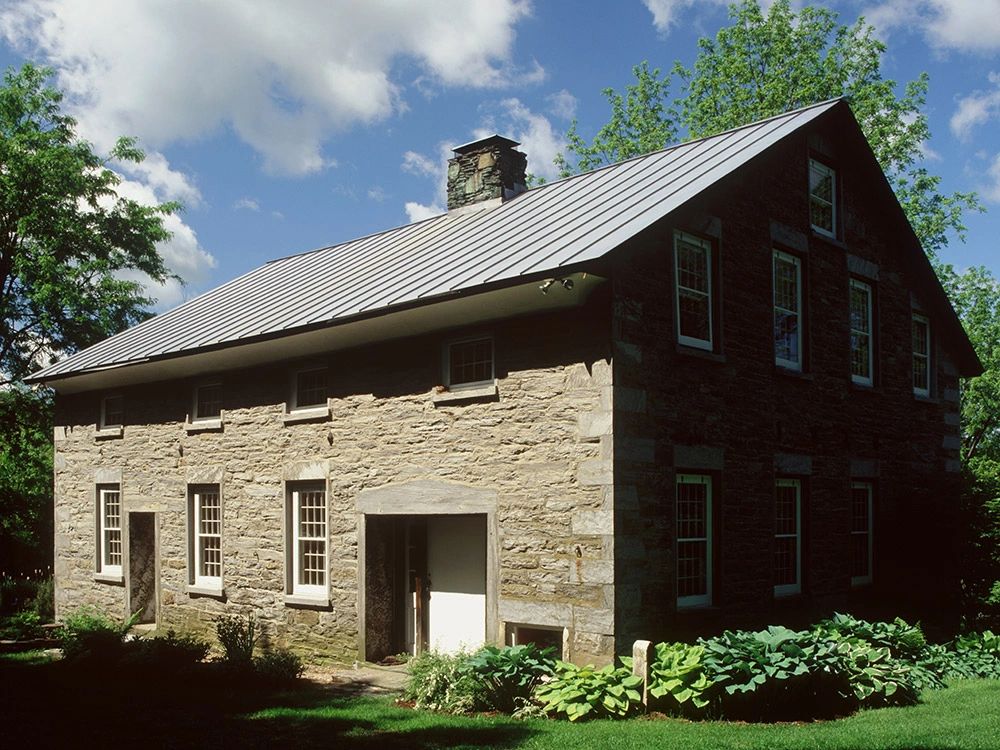 Stone house with a gray standing seam roof