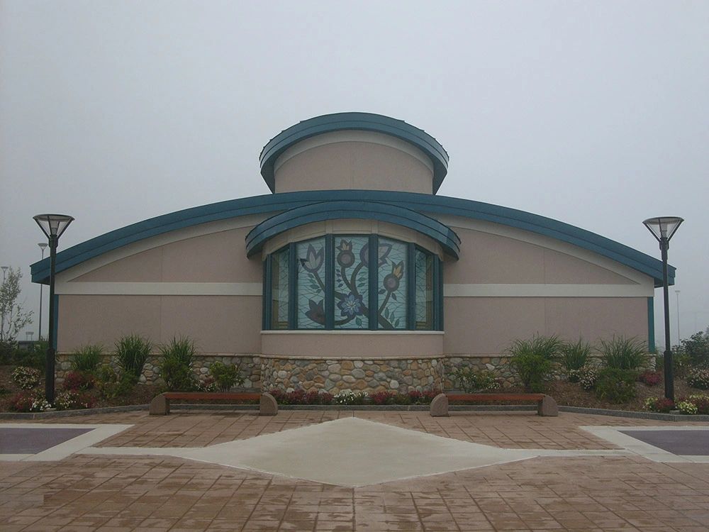 Curved metal roof above a large arched window