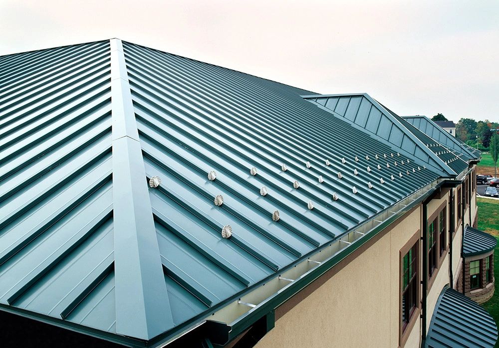Close view of green metal roof ridges and hips